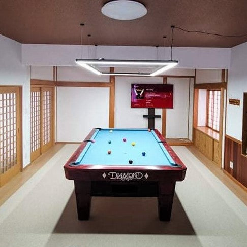 A pool table light illuminates the entire game room